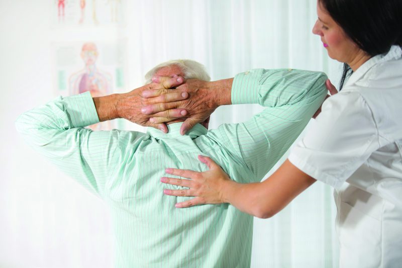 Pain Management Online Graduate Certificate Image of Nurse Pain Specialist Helping Patient Using Applied Back Pressure