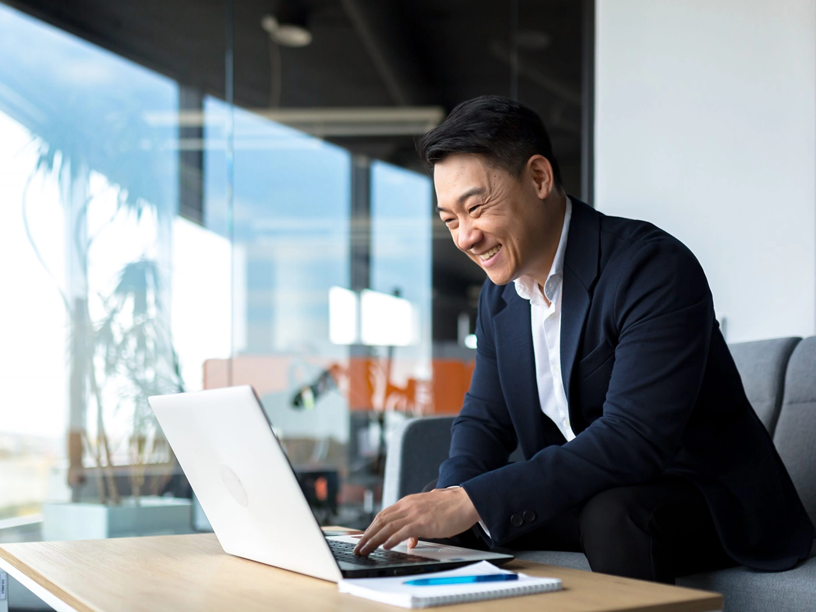 Asian business professional working on laptop.
